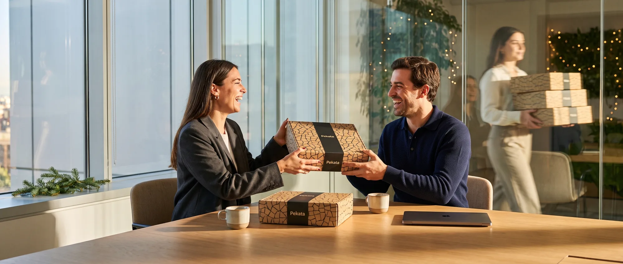 Übergabe einer Pekata-Geschenkbox zwischen zwei Fachleuten in einem Besprechungsraum